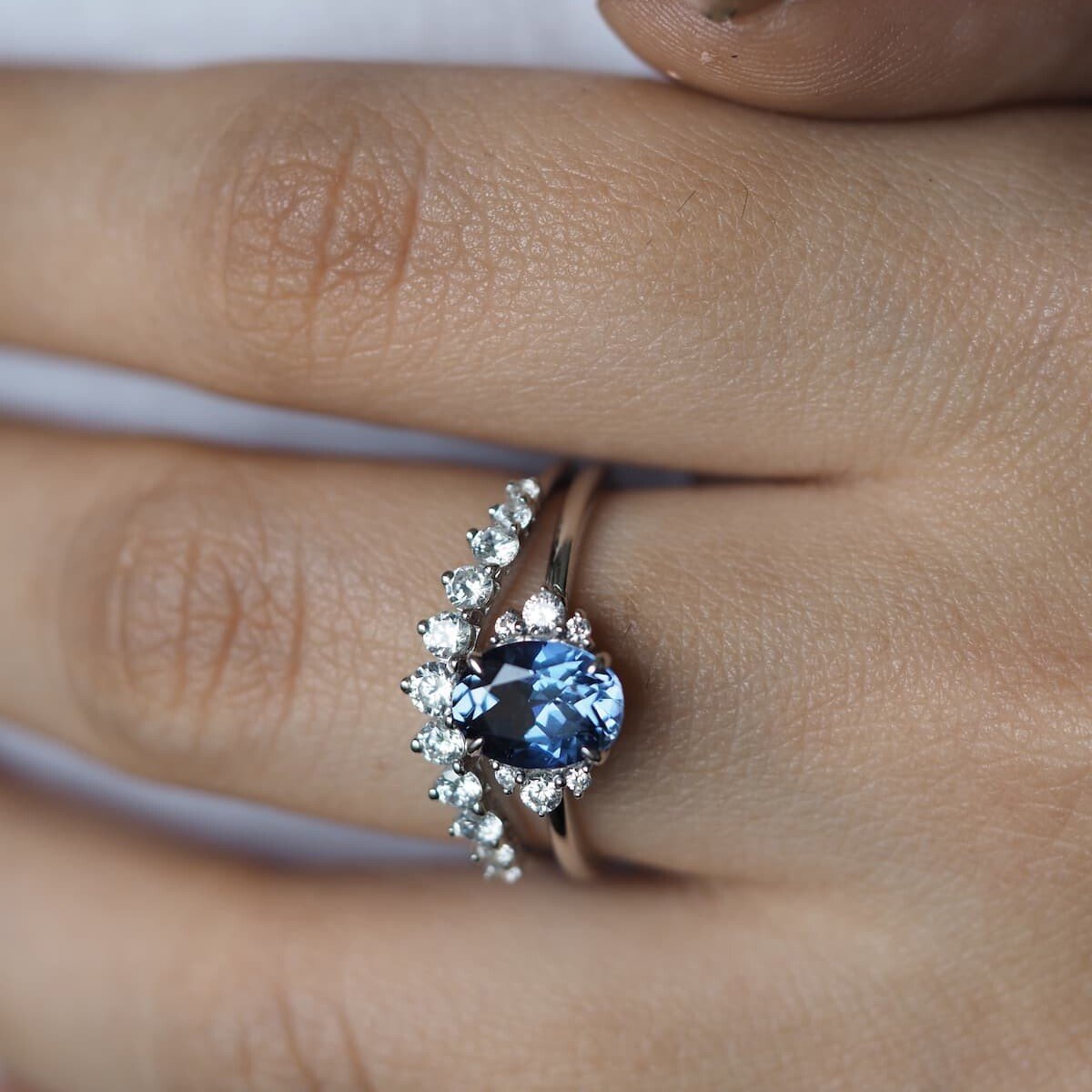 Sophia Blue Sapphire Ring shown on a hand model. With diamond band.